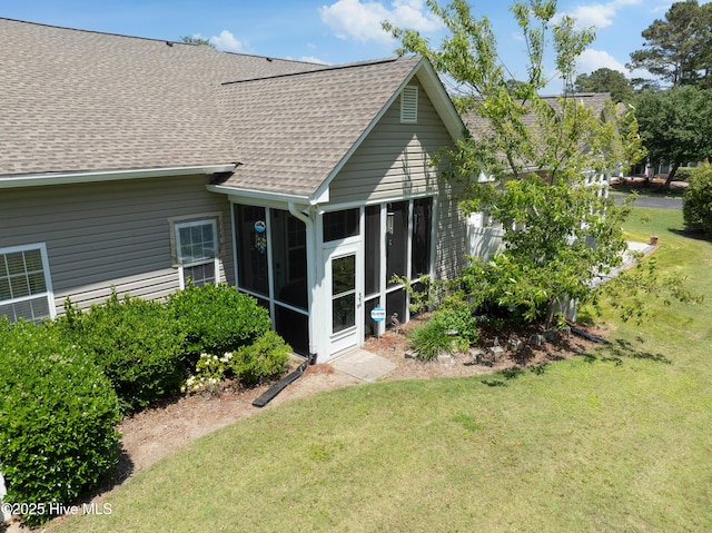 4256 Anderson Dr SE, Southport, NC 28461 - rear view of property featuring roof with shingles, a yard, and a sunroom