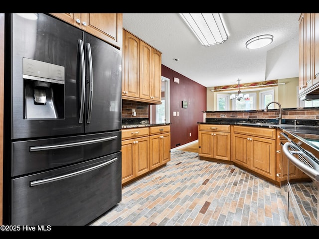 71 Combine Ln SE, Leland, NC 28451 - kitchen featuring black refrigerator with ice dispenser, decorative backsplash, a peninsula, and brick patterned floors