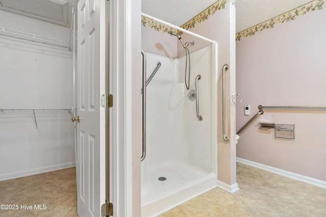 71 Combine Ln SE, Leland, NC 28451 - full bathroom featuring a shower stall, a walk in closet, baseboards, and a textured ceiling
