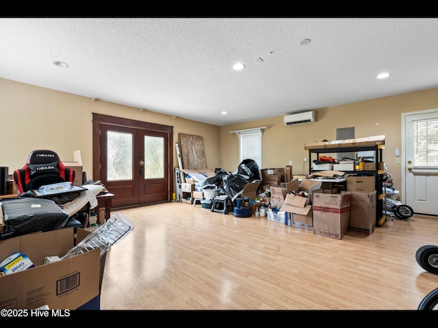 71 Combine Ln SE, Leland, NC 28451 - misc room featuring wood finished floors, a textured ceiling, a wall mounted air conditioner, french doors, and recessed lighting
