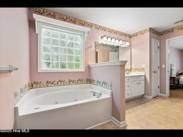 71 Combine Ln SE, Leland, NC 28451 - bathroom featuring vanity, a tub with jets, a textured ceiling, tile patterned floors, and baseboards