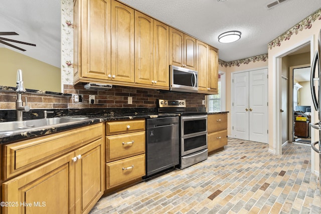 71 Combine Ln SE, Leland, NC 28451 - kitchen featuring appliances with stainless steel finishes, backsplash, a sink, a ceiling fan, and brick patterned flooring