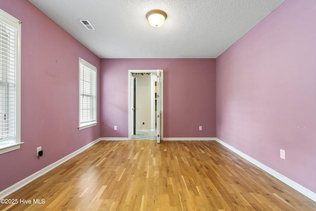 71 Combine Ln SE, Leland, NC 28451 - unfurnished bedroom with light wood-style floors, a textured ceiling, and baseboards