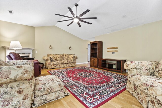 71 Combine Ln SE, Leland, NC 28451 - living room featuring a ceiling fan, vaulted ceiling, wood finished floors, and a fireplace