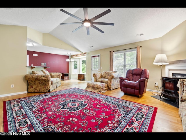 71 Combine Ln SE, Leland, NC 28451 - living area with a ceiling fan, vaulted ceiling, wood finished floors, and a wood stove