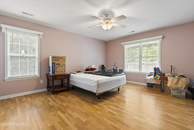 71 Combine Ln SE, Leland, NC 28451 - bedroom featuring light wood-style floors, baseboards, a textured ceiling, and ceiling fan