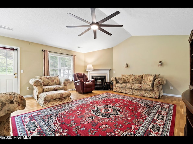 71 Combine Ln SE, Leland, NC 28451 - living room with ceiling fan, plenty of natural light, lofted ceiling, wood finished floors, and a glass covered fireplace