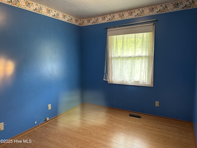 2611 Lisa Ln, Goldsboro, NC 27534 - empty room featuring wood finished floors, a textured ceiling, and baseboards