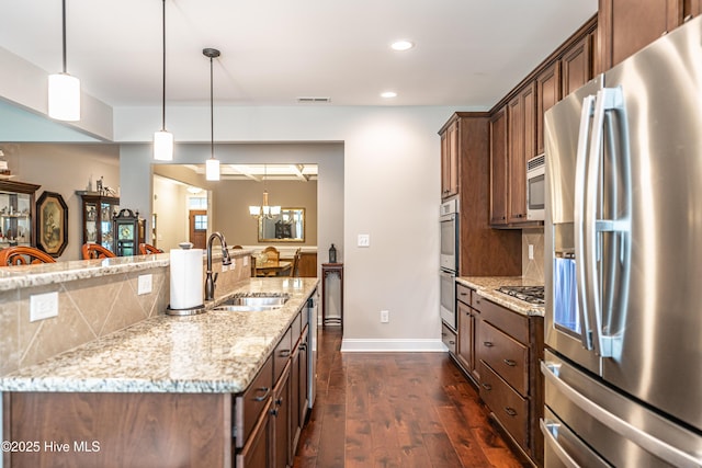 255 Champions Ridge Dr, Southern Pines, NC 28387 - kitchen featuring appliances with stainless steel finishes, a sink, dark wood-type flooring, light stone counters, and tasteful backsplash
