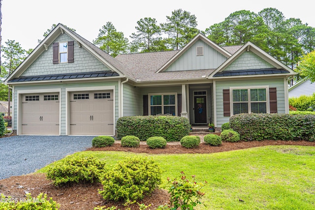 255 Champions Ridge Dr, Southern Pines, NC 28387 - craftsman-style house with board and batten siding, driveway, a standing seam roof, a front yard, and an attached garage