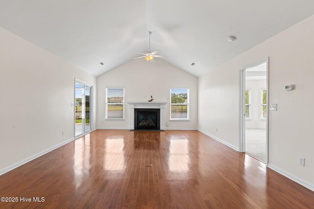 770 Heather Glen Ln, Calabash, NC 28467 - unfurnished living room with wood finished floors, ceiling fan, a fireplace with flush hearth, vaulted ceiling, and baseboards