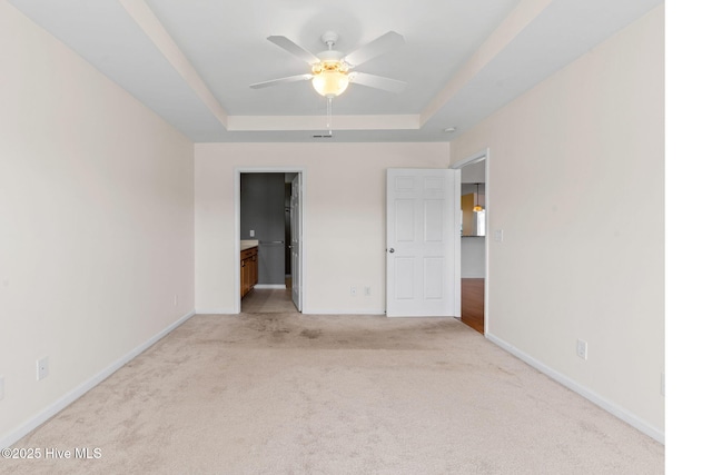 770 Heather Glen Ln, Calabash, NC 28467 - unfurnished bedroom with a tray ceiling, light colored carpet, baseboards, and ensuite bathroom