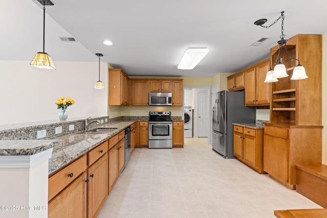 770 Heather Glen Ln, Calabash, NC 28467 - kitchen featuring stainless steel appliances, a sink, washer / dryer, stone countertops, and a peninsula