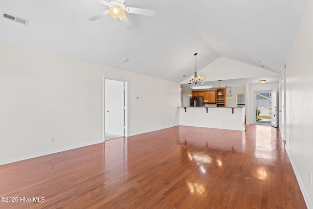 770 Heather Glen Ln, Calabash, NC 28467 - unfurnished living room with lofted ceiling, wood finished floors, a chandelier, a ceiling fan, and baseboards