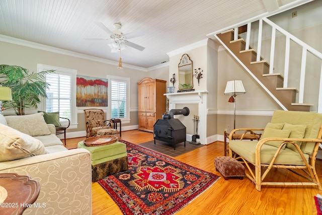 1402 Shepard St, Morehead City, NC 28557 - living room featuring wood finished floors, a wood stove, a ceiling fan, ornamental molding, and stairway