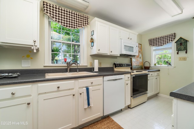 1402 Shepard St, Morehead City, NC 28557 - kitchen with white appliances, a sink, and dark countertops
