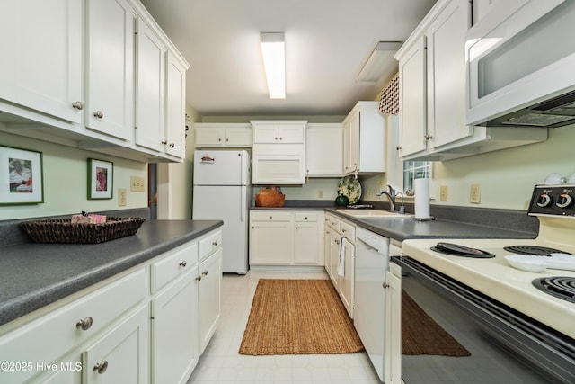 1402 Shepard St, Morehead City, NC 28557 - kitchen with white appliances, white cabinets, a sink, dark countertops, and light flooring