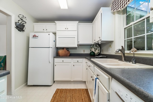 1402 Shepard St, Morehead City, NC 28557 - kitchen featuring white appliances, a sink, white cabinets, dark countertops, and baseboards