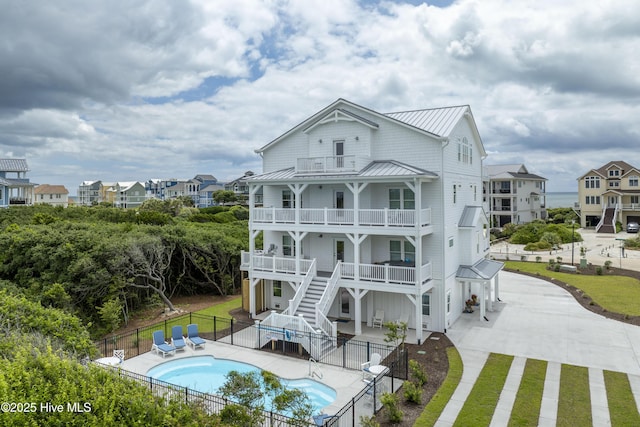 145 Oceanview Ln, North Topsail Beach, NC 28460 - back of property with a balcony, a standing seam roof, stairs, metal roof, and a patio area