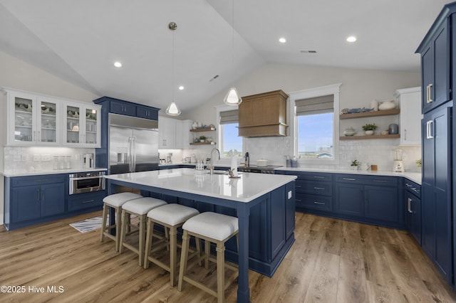 145 Oceanview Ln, North Topsail Beach, NC 28460 - kitchen featuring open shelves, vaulted ceiling, blue cabinets, stainless steel built in fridge, and a kitchen bar