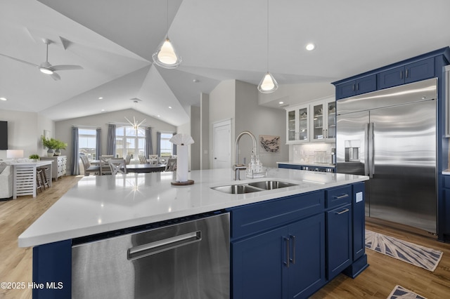 145 Oceanview Ln, North Topsail Beach, NC 28460 - kitchen with a sink, stainless steel appliances, open floor plan, blue cabinets, and lofted ceiling