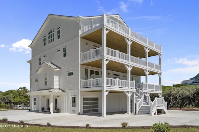 145 Oceanview Ln, North Topsail Beach, NC 28460 - rear view of property with an attached garage, concrete driveway, board and batten siding, and a balcony