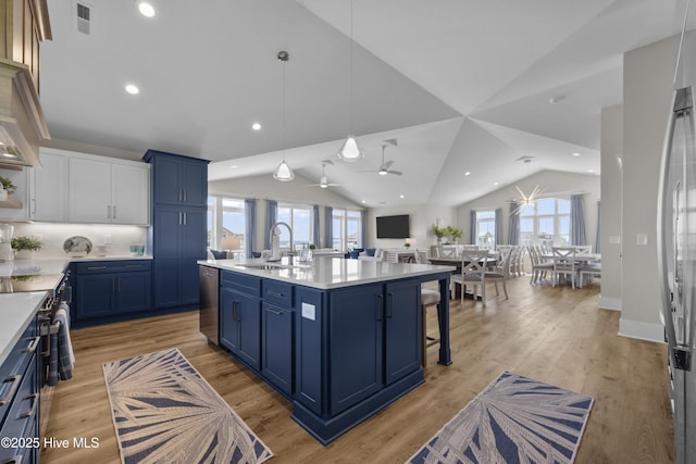 145 Oceanview Ln, North Topsail Beach, NC 28460 - kitchen featuring blue cabinets, vaulted ceiling, a sink, open floor plan, and light countertops
