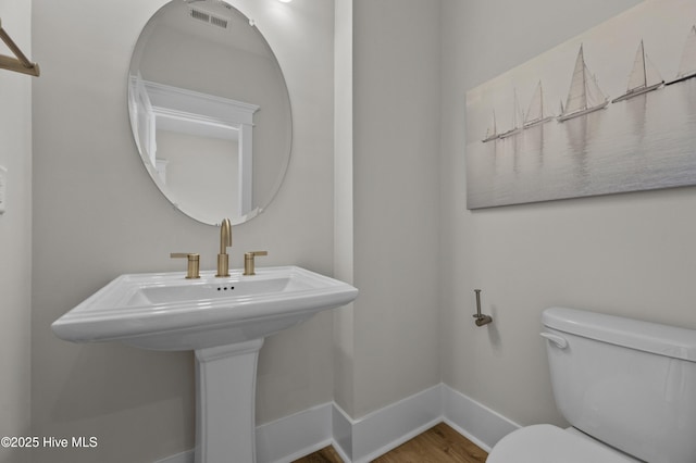 145 Oceanview Ln, North Topsail Beach, NC 28460 - bathroom with toilet, baseboards, wood finished floors, and a sink