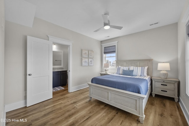 145 Oceanview Ln, North Topsail Beach, NC 28460 - bedroom with light wood finished floors, baseboards, connected bathroom, and ceiling fan