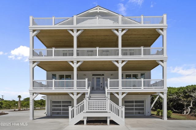 145 Oceanview Ln, North Topsail Beach, NC 28460 - coastal inspired home with an attached garage, a porch, stairs, and a balcony