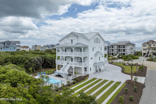 145 Oceanview Ln, North Topsail Beach, NC 28460 - view of front facade featuring a balcony, driveway, a standing seam roof, stairs, and metal roof