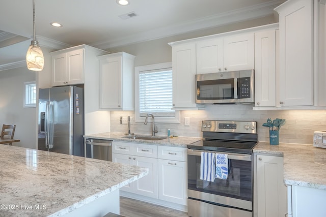 876-878 Villas Dr, North Topsail Beach, NC 28460 - kitchen featuring stainless steel appliances, a sink, ornamental molding, white cabinetry, and tasteful backsplash