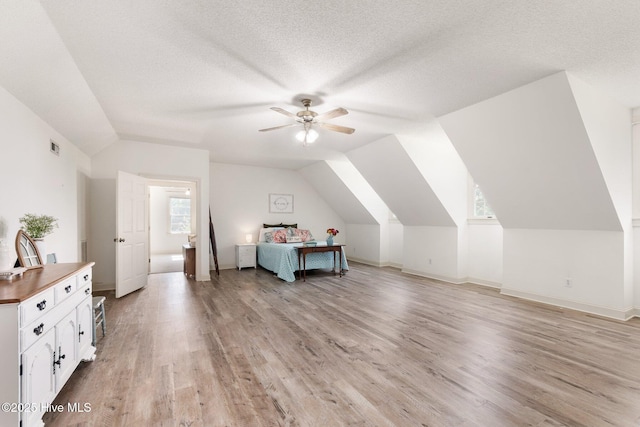 116 Spencer Ln, Newport, NC 28570 - bedroom with vaulted ceiling, light wood-style floors, a ceiling fan, and a textured ceiling