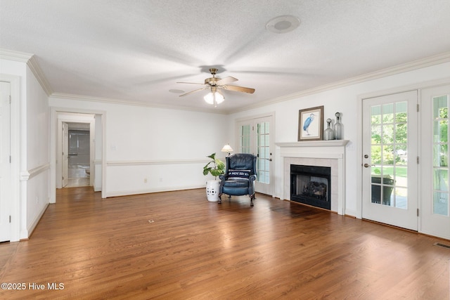 116 Spencer Ln, Newport, NC 28570 - unfurnished living room featuring a fireplace, a ceiling fan, wood finished floors, ornamental molding, and a textured ceiling