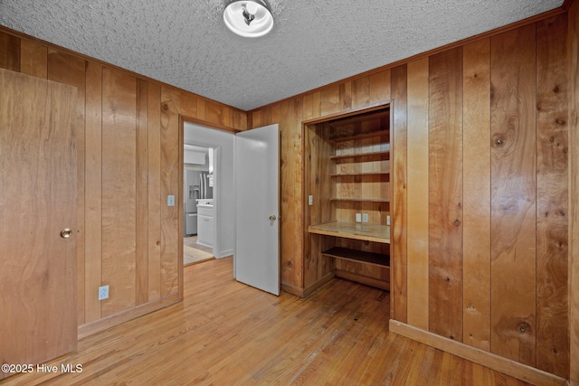 2411 Grace Ave, New Bern, NC 28562 - empty room featuring wood walls, light wood-style flooring, and a textured ceiling