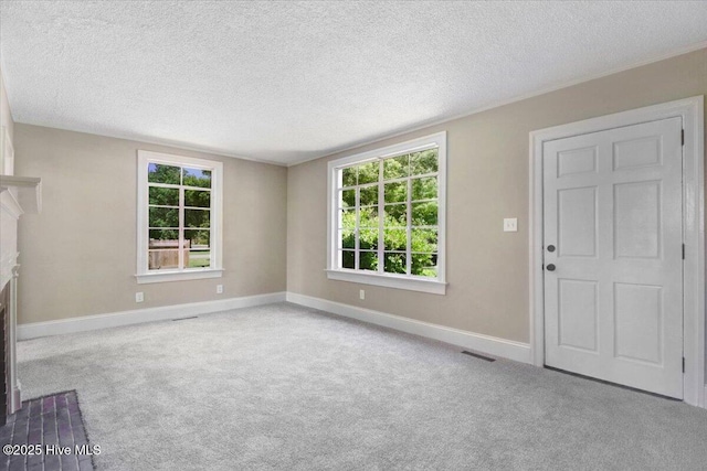 403 S Andrews Ave, Goldsboro, NC 27530 - unfurnished living room featuring baseboards, carpet flooring, a textured ceiling, and healthy amount of natural light