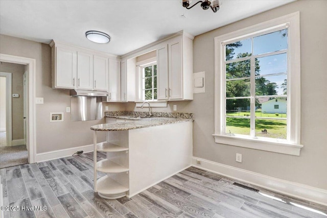 403 S Andrews Ave, Goldsboro, NC 27530 - kitchen with white cabinets, light wood-type flooring, light stone counters, and under cabinet range hood