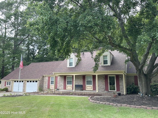 113 Perry Dr, Goldsboro, NC 27530 - new england style home with an attached garage, brick siding, a front yard, a porch, and concrete driveway