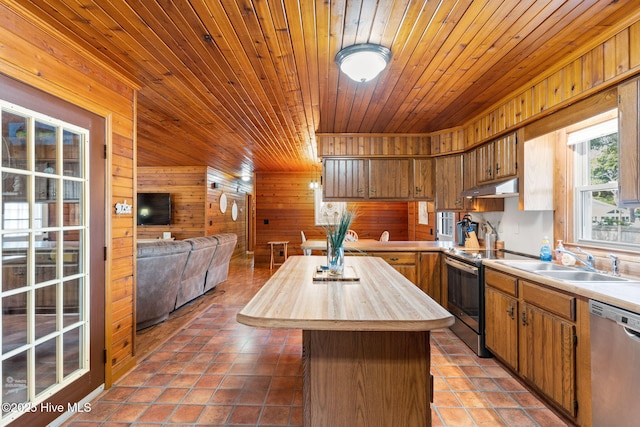 103 NE 17th St, Oak Island, NC 28465 - kitchen featuring stainless steel appliances, butcher block counters, wood walls, a sink, and wood ceiling