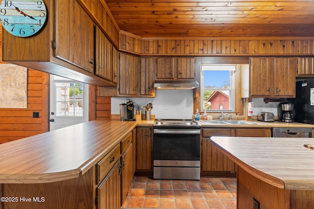 103 NE 17th St, Oak Island, NC 28465 - kitchen featuring stainless steel appliances, a sink, under cabinet range hood, a peninsula, and healthy amount of natural light