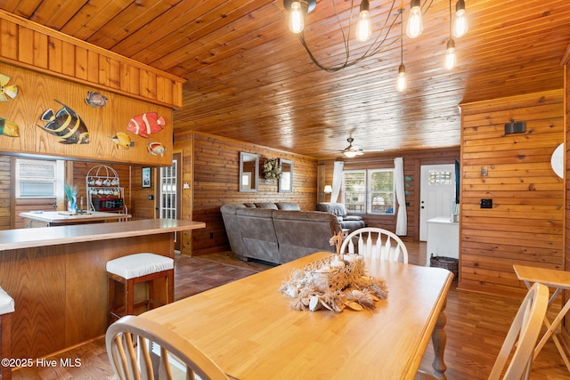 103 NE 17th St, Oak Island, NC 28465 - dining area featuring wood walls, wooden ceiling, dark wood-type flooring, and a ceiling fan