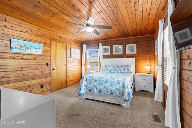 103 NE 17th St, Oak Island, NC 28465 - carpeted bedroom with wood walls, wooden ceiling, and a ceiling fan
