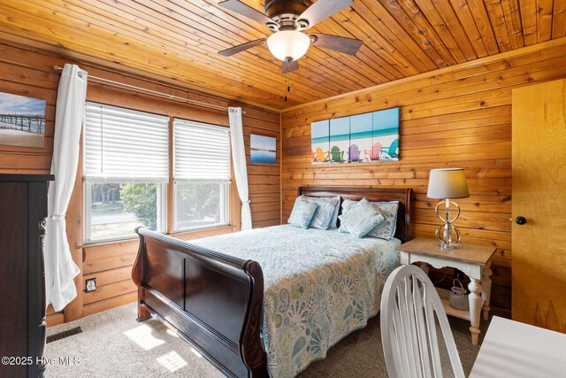 103 NE 17th St, Oak Island, NC 28465 - carpeted bedroom featuring wooden ceiling, wooden walls, and ceiling fan