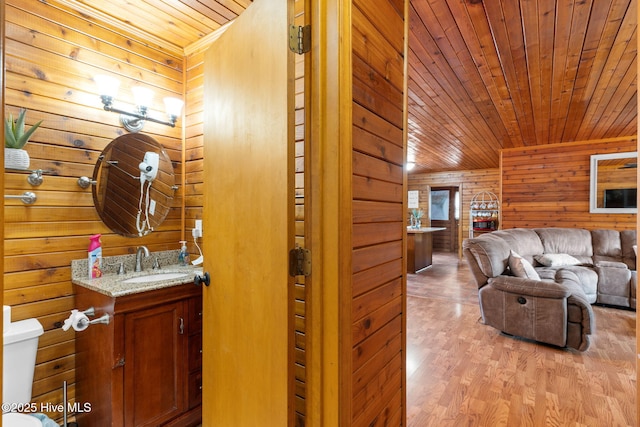 103 NE 17th St, Oak Island, NC 28465 - living room with wooden ceiling, wood walls, and light wood-style flooring