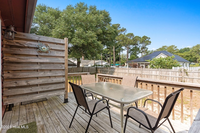 103 NE 17th St, Oak Island, NC 28465 - wooden terrace featuring outdoor dining space and a fenced backyard