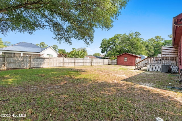 103 NE 17th St, Oak Island, NC 28465 - view of yard featuring central AC unit, a wooden deck, and an outbuilding