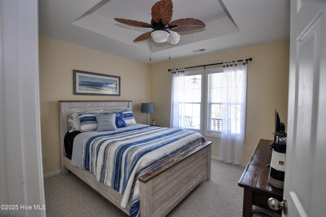 505 Sunset Oaks Ln, Sunset Beach, NC 28468 - bedroom featuring a raised ceiling, light carpet, and baseboards