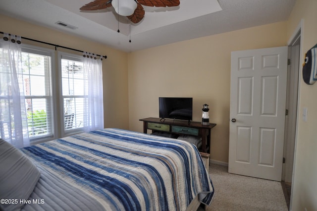 505 Sunset Oaks Ln, Sunset Beach, NC 28468 - bedroom featuring light colored carpet, a tray ceiling, ceiling fan, and baseboards