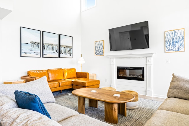 271 E Second St, Ocean Isle Beach, NC 28469 - living room with a glass covered fireplace, a towering ceiling, wood finished floors, and baseboards