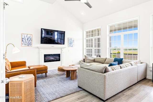 271 E Second St, Ocean Isle Beach, NC 28469 - living room with high vaulted ceiling, light wood-style floors, ceiling fan, and a glass covered fireplace